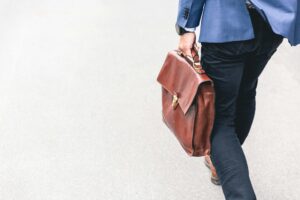 person-walking-holding-brown-leather-bag-6dW3xyQvcYE